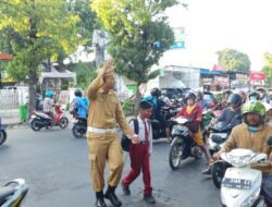 Polisi “Pejuang”  di Situbondo Atur Lalu Lintas dan Menyeberangkan Anak Sekolah