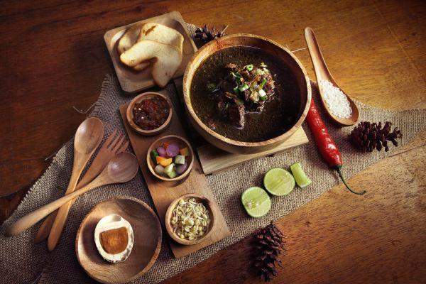 Semangkuk rawon Jawa Timur dengan pelengkap tauge, telur asin, dan kerupuk